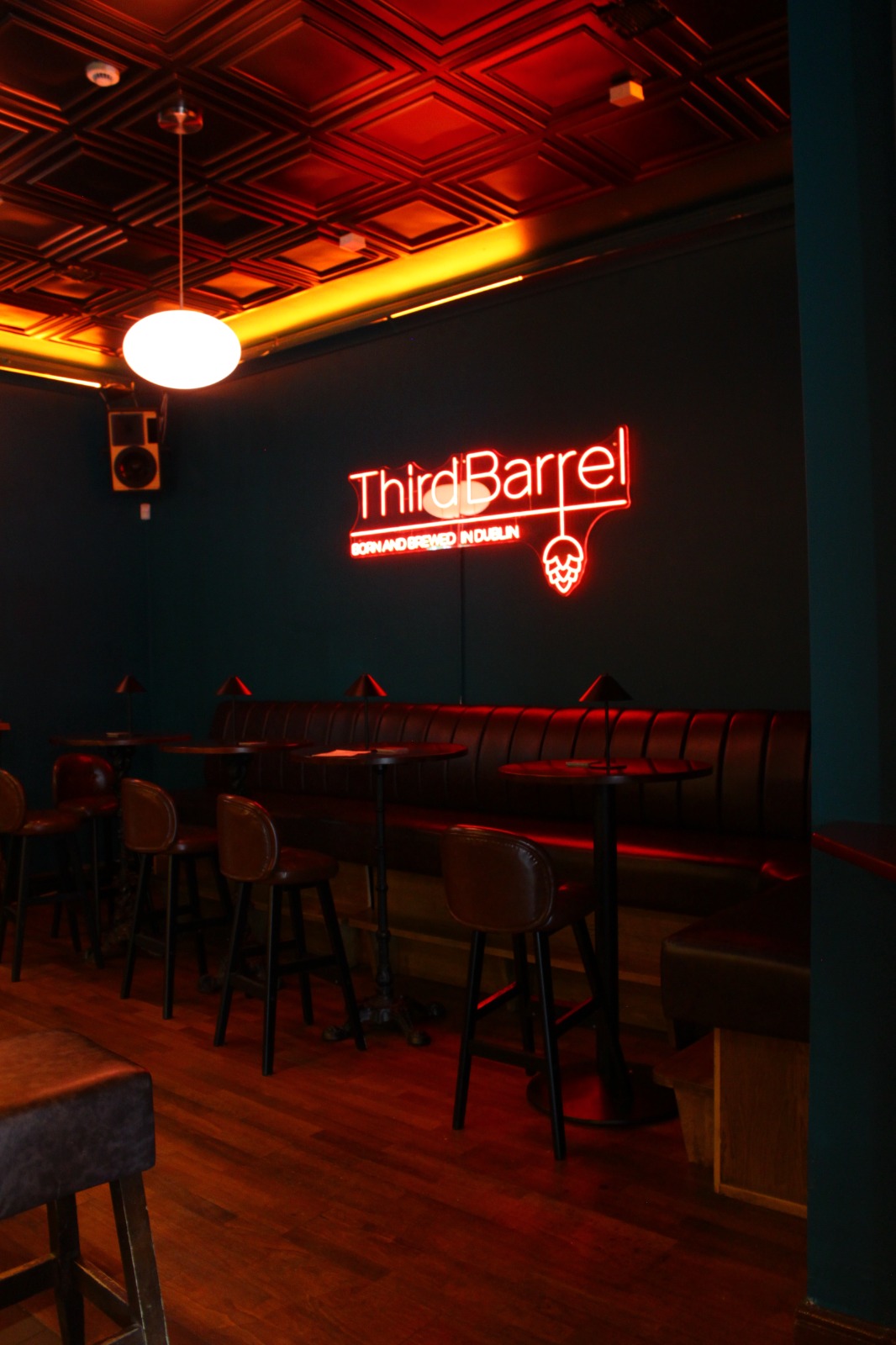 The Bar at The Christchurch — booth seating beneath the Third Barrel neon sign